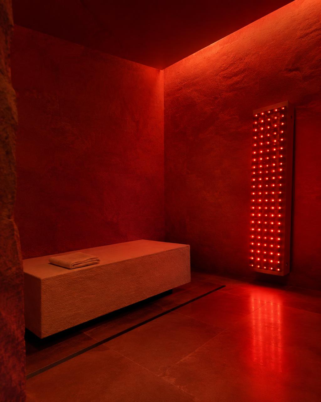 A stone bench beneath the glow of a red light therapy panel